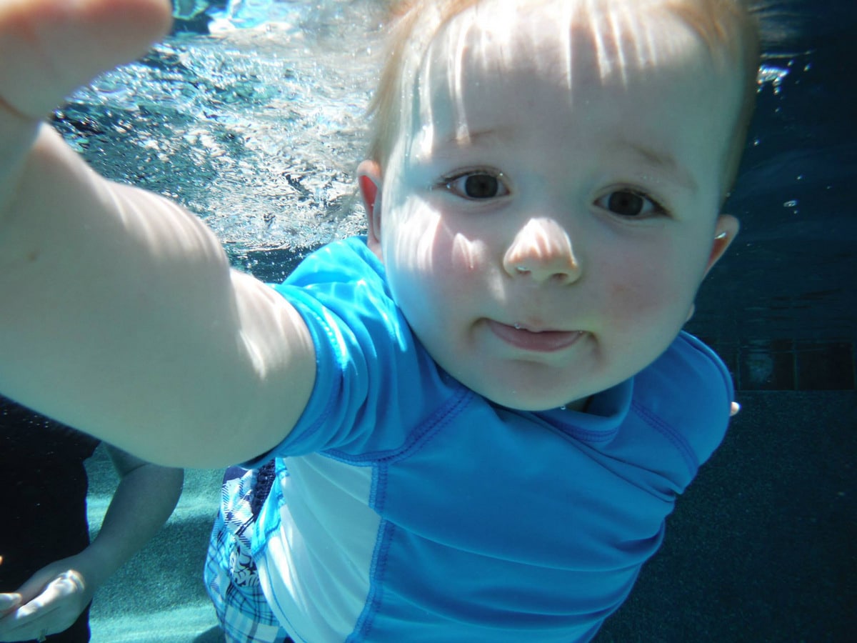 18 month old baby having infant self-rescue swimming lesson