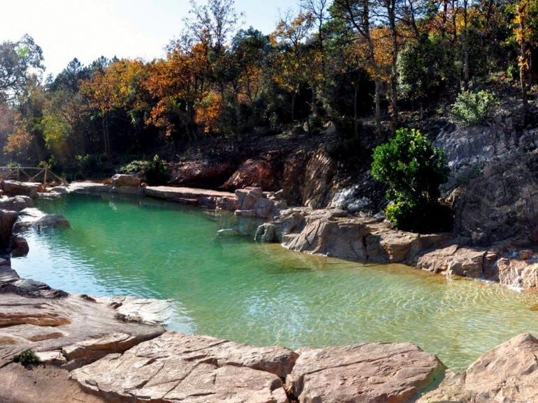 A huge natural swimming pool tucked into a hillside