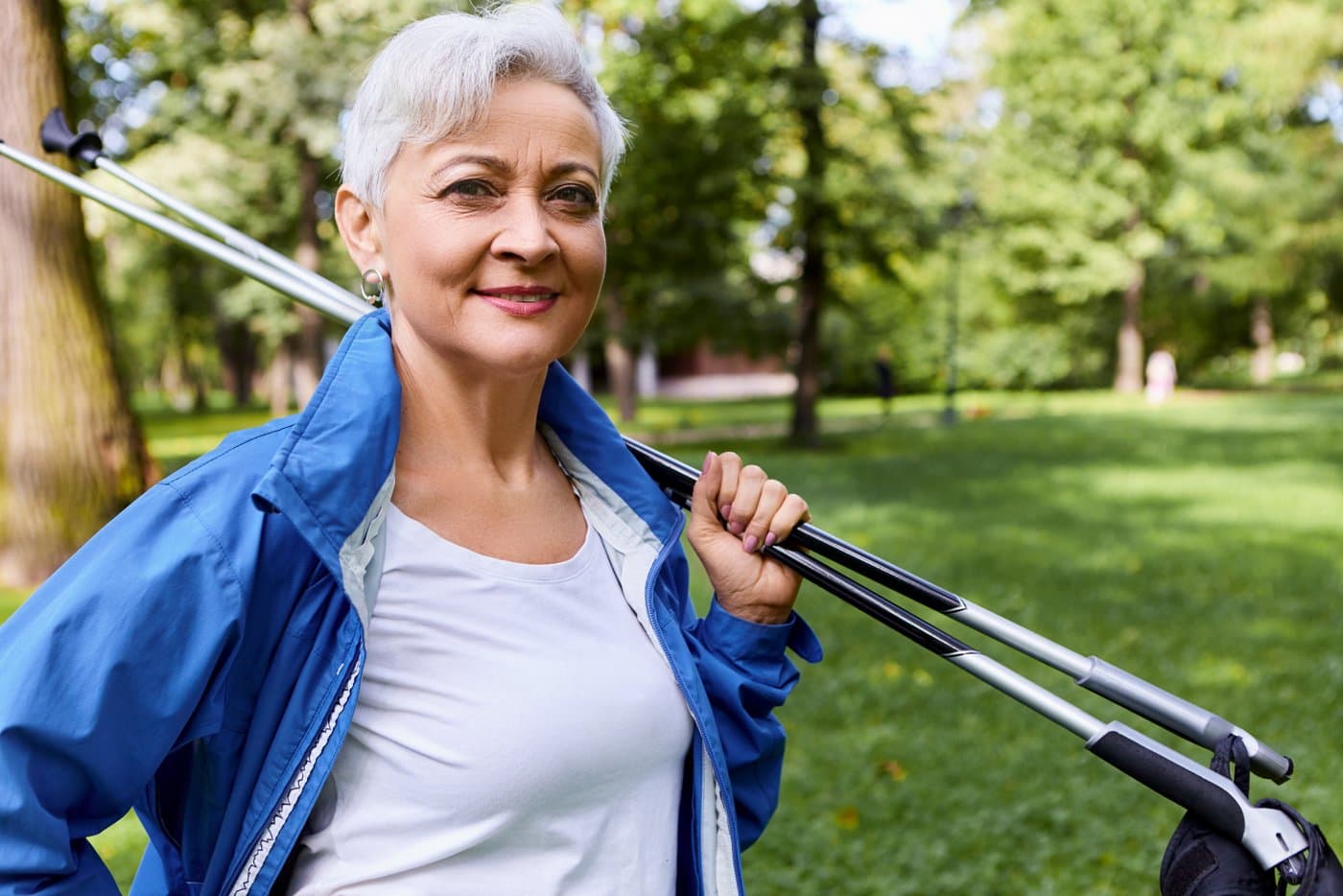 A woman standing outside holding two Nordic walking poles