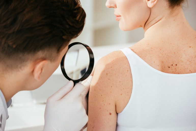 Dermatologist looking closely at a woman's skin