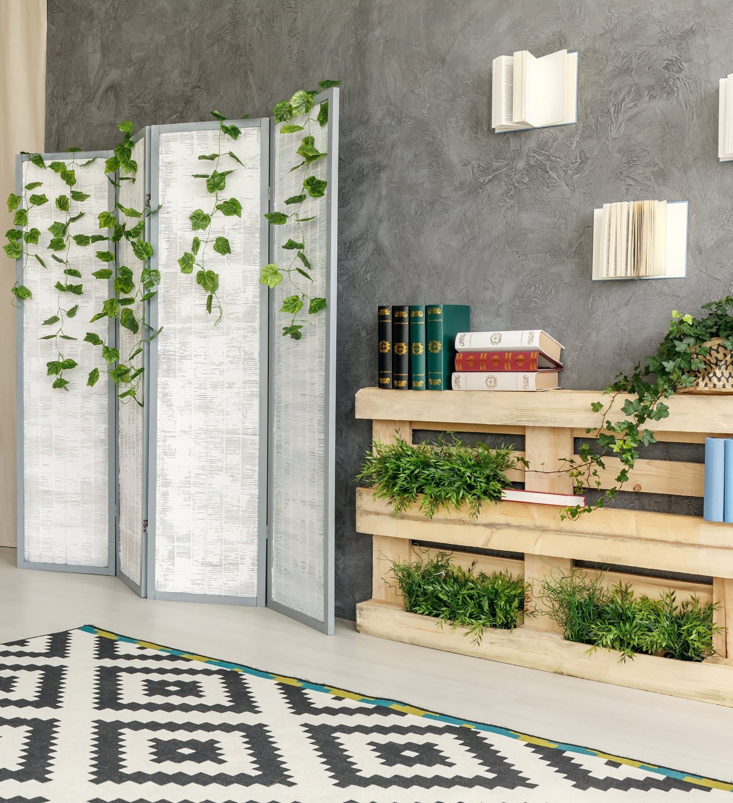 Indoor plants decorating: Green plants built into a bookshelf and ivy hanging from a divider