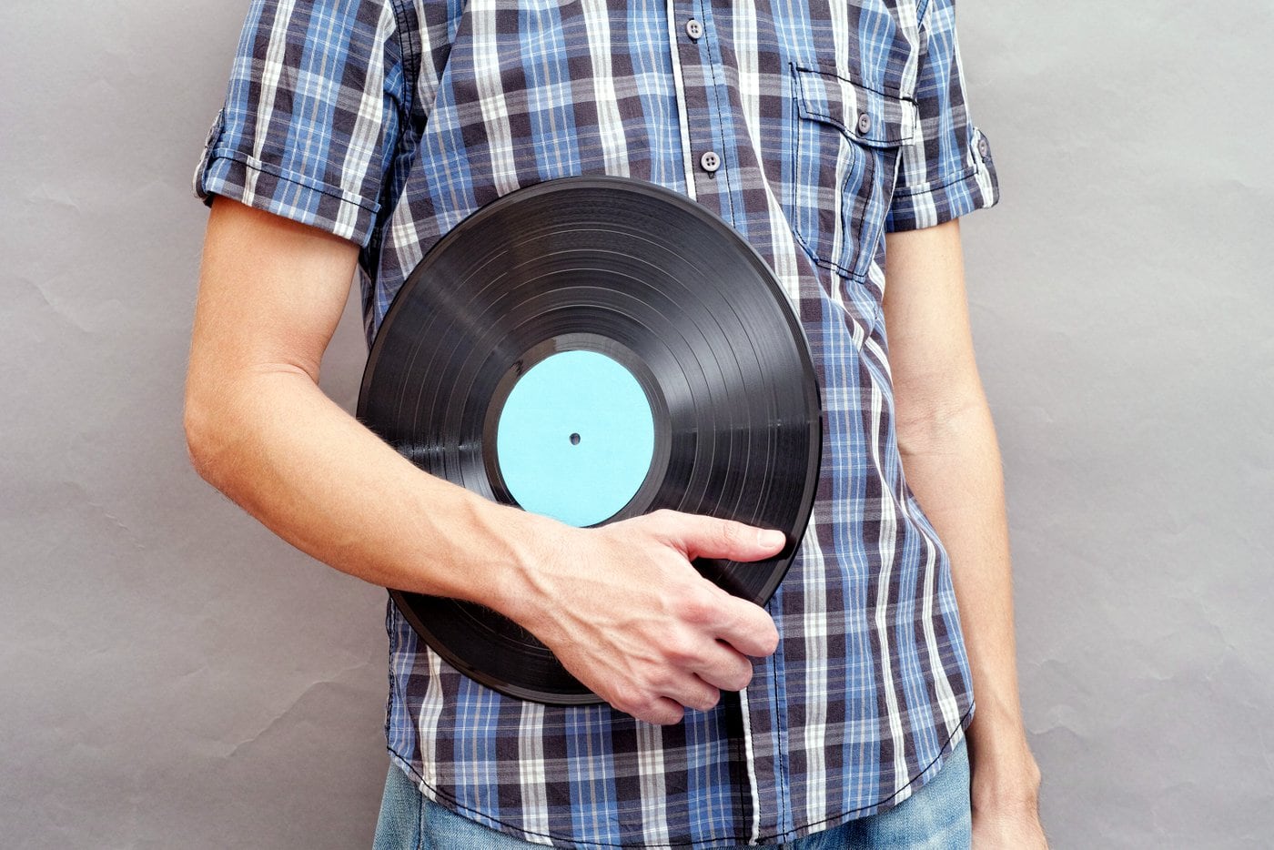 Man casually holding a vinyl record - destroying its integrity foreverrrr