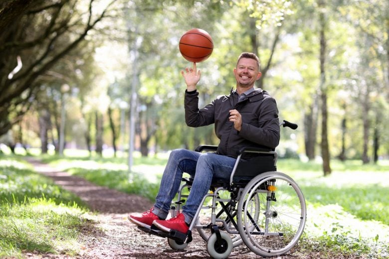 Man in a wheelchair spinning a basketball