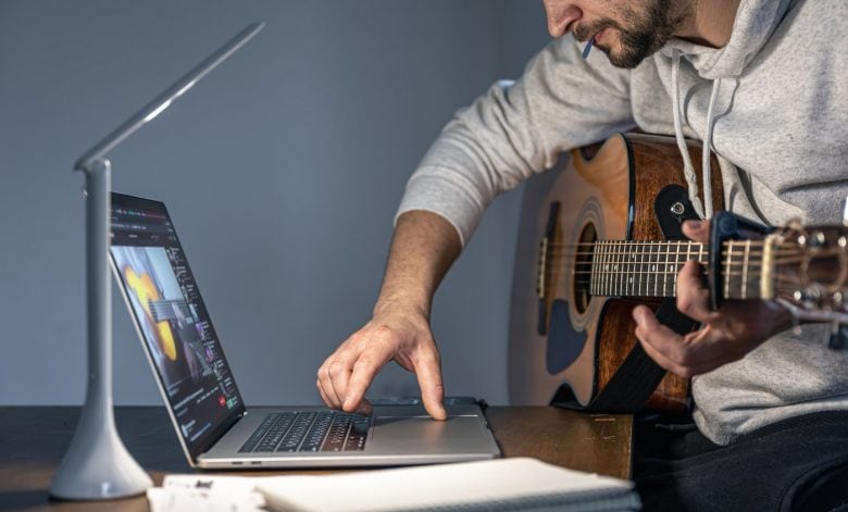 Man learning how to play guitar with online tutorials