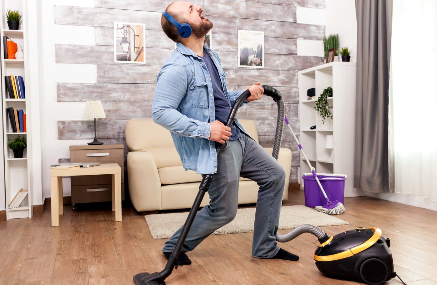 Man rocking out whild doing the vacuuming