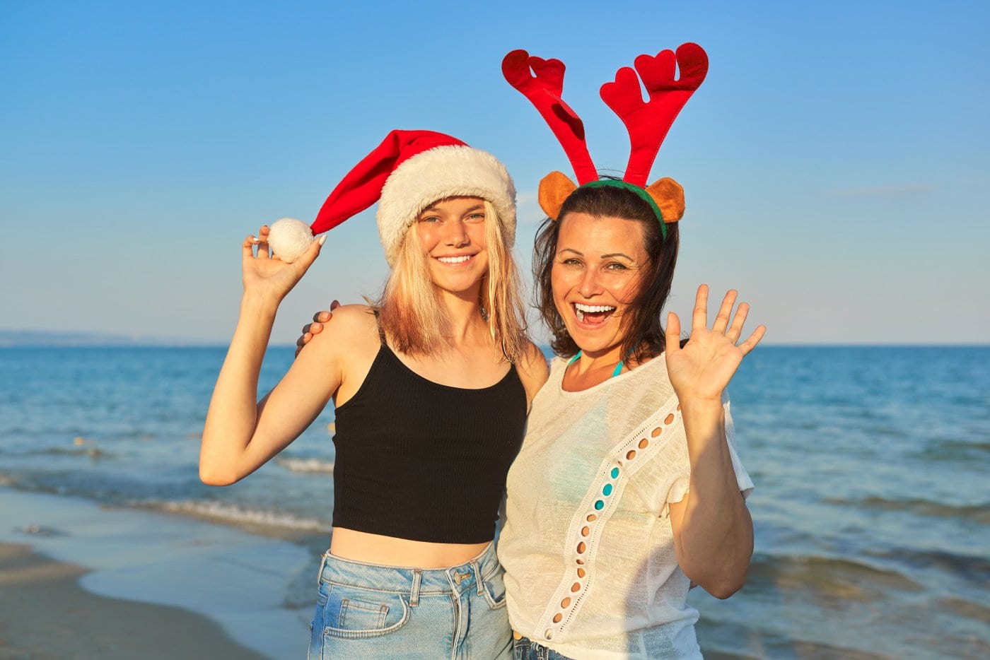 Mom and college-age daughter at the beach near Christmas time