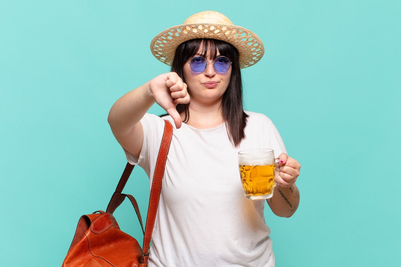 Traveling woman with a beer giving a thumbs down