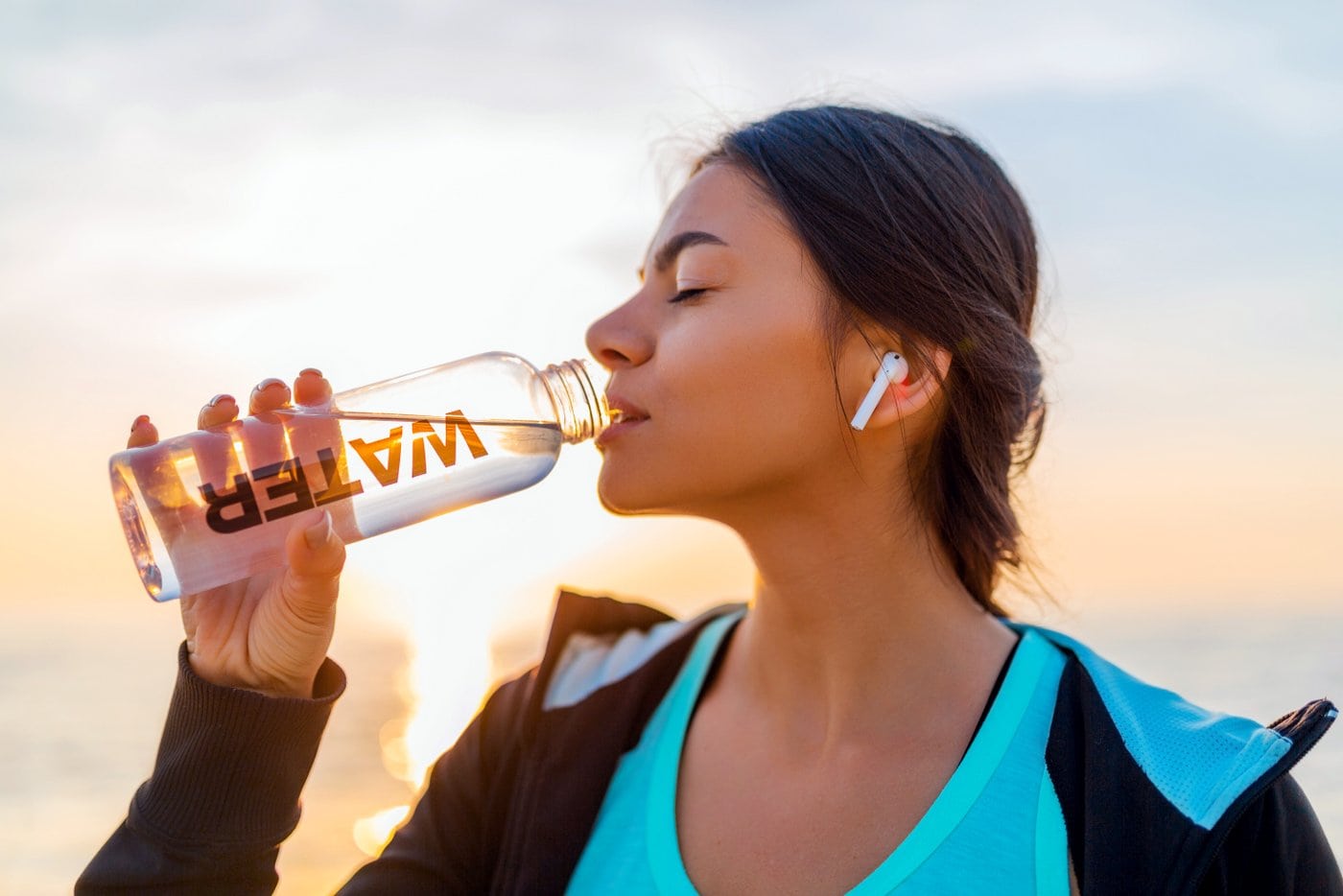 Woman drinking water after workout outside