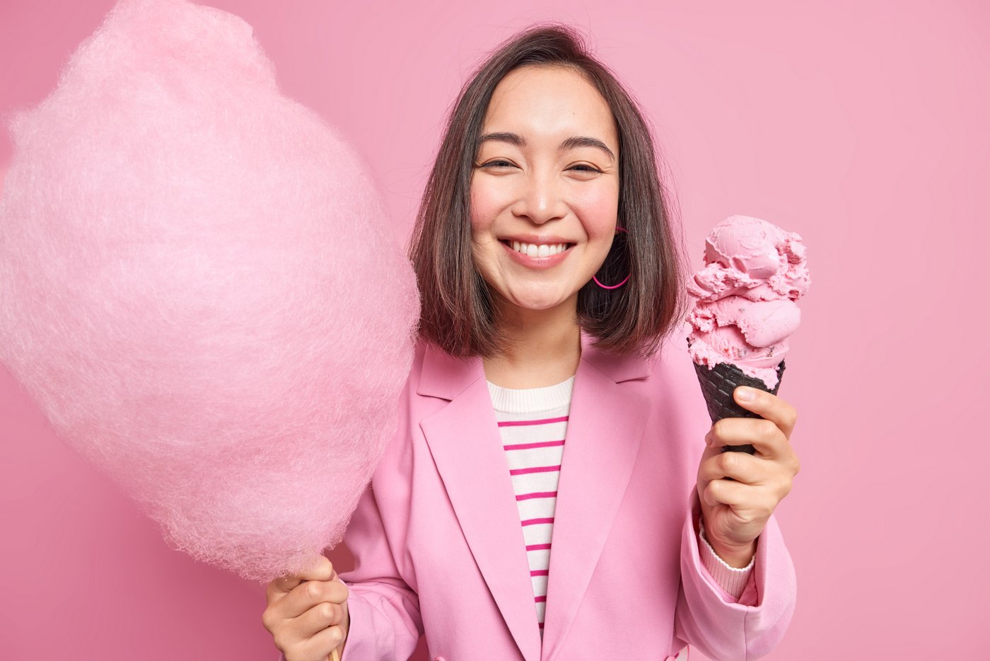 Woman happy with pink cotton candy and pink ice cream