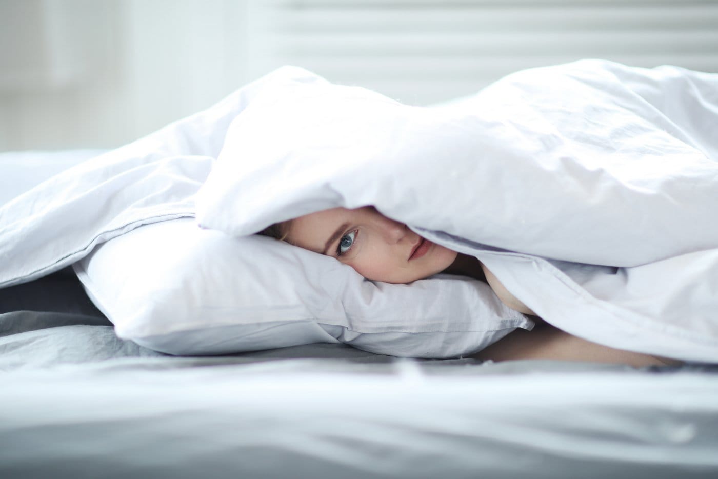 Woman in bed under a comforter in a duvet cover