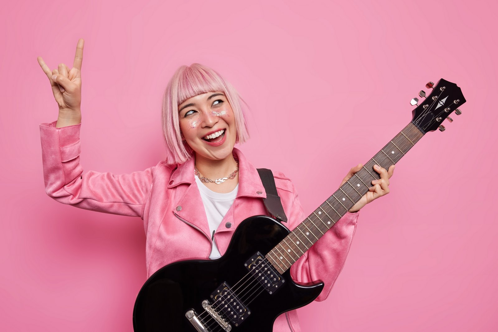 Woman rockstar with guitar and pink hair
