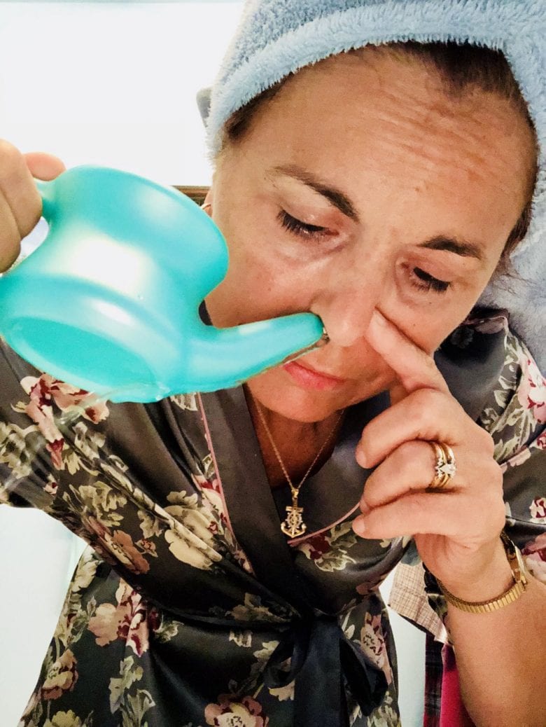 Woman using a neti pot in her nose