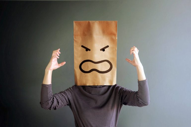 Woman with angry face on a paper bag over her head