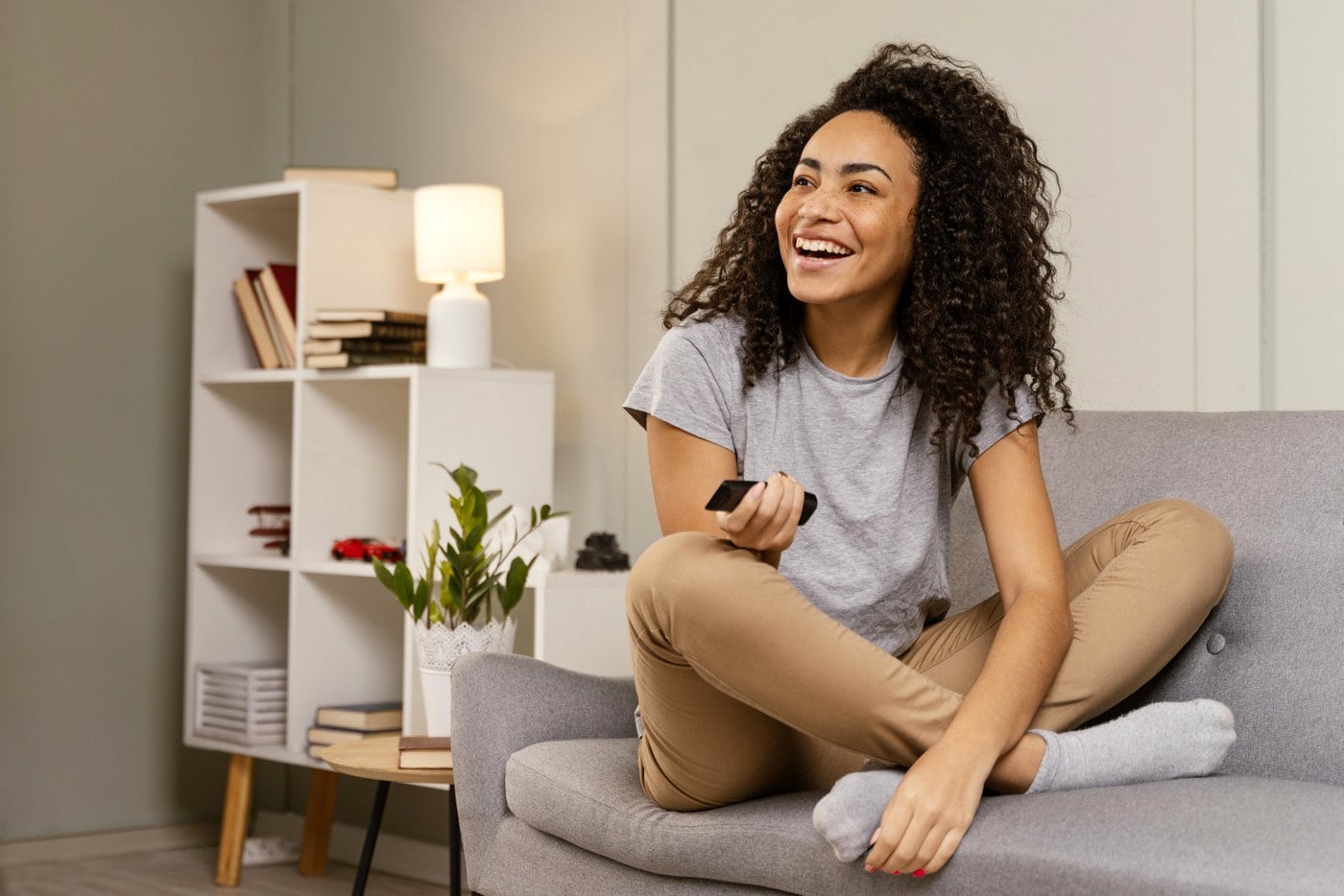 Woman with remote control for the TV streaming services